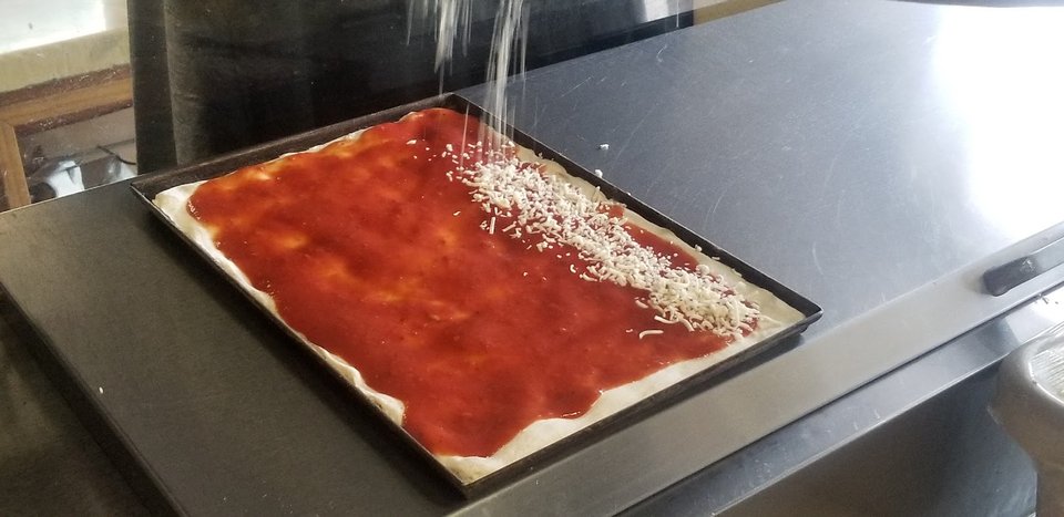 Chicken wings served beside pizza slices.