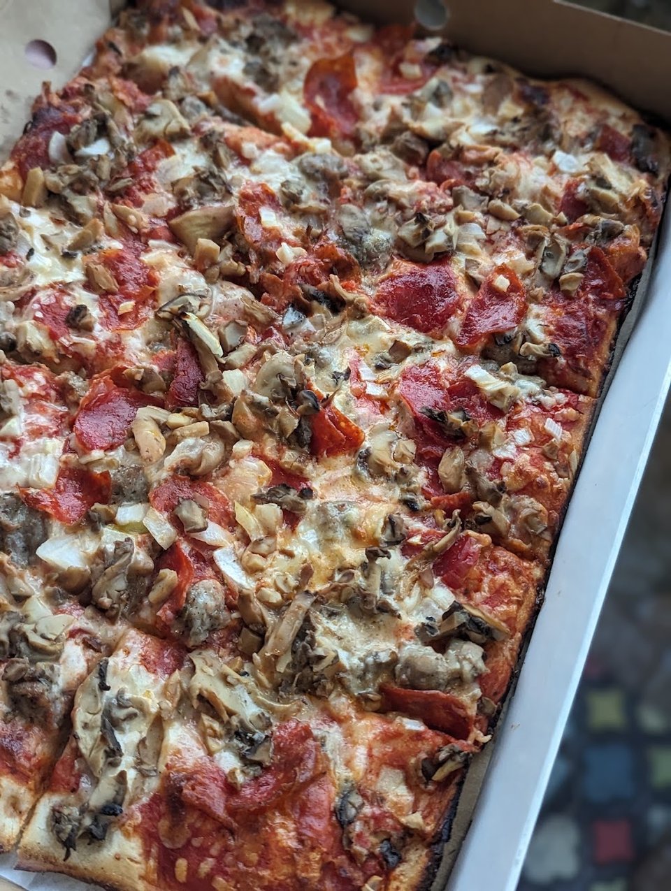 Menu board with pizza and wings.